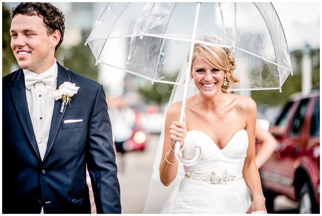 bride holding umbrella because she prepared for rain during her cleveland wedding planning