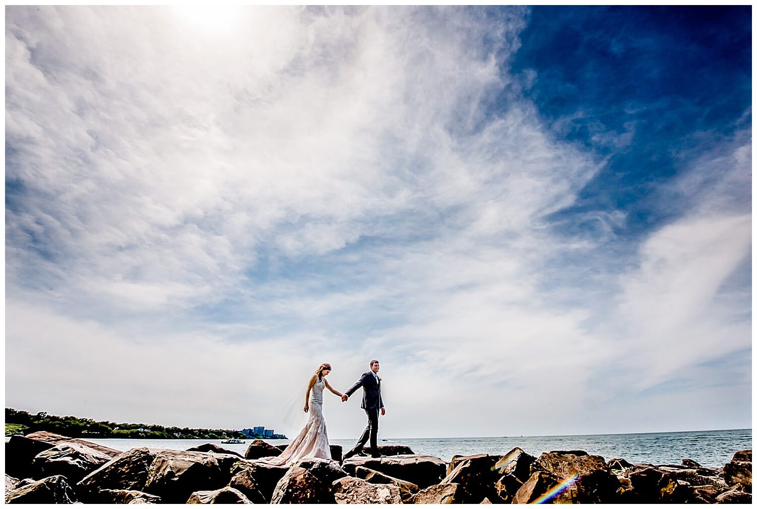 ohio wedding photographer picture of couple walking on the rocks on lake erie in downtown cleveland