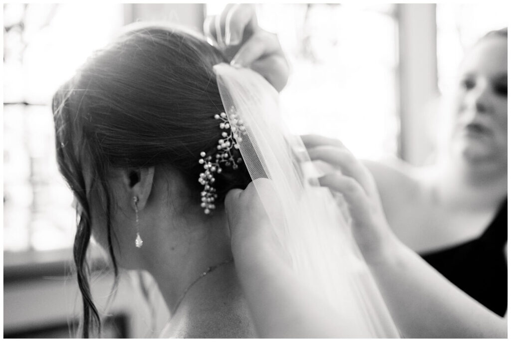black and white photo of bride getting veil on at st marys church on wedding day