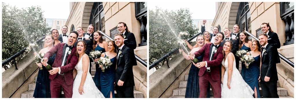 bride and groom popping a bottle of champagne with bridal party on the steps in downtown canton
