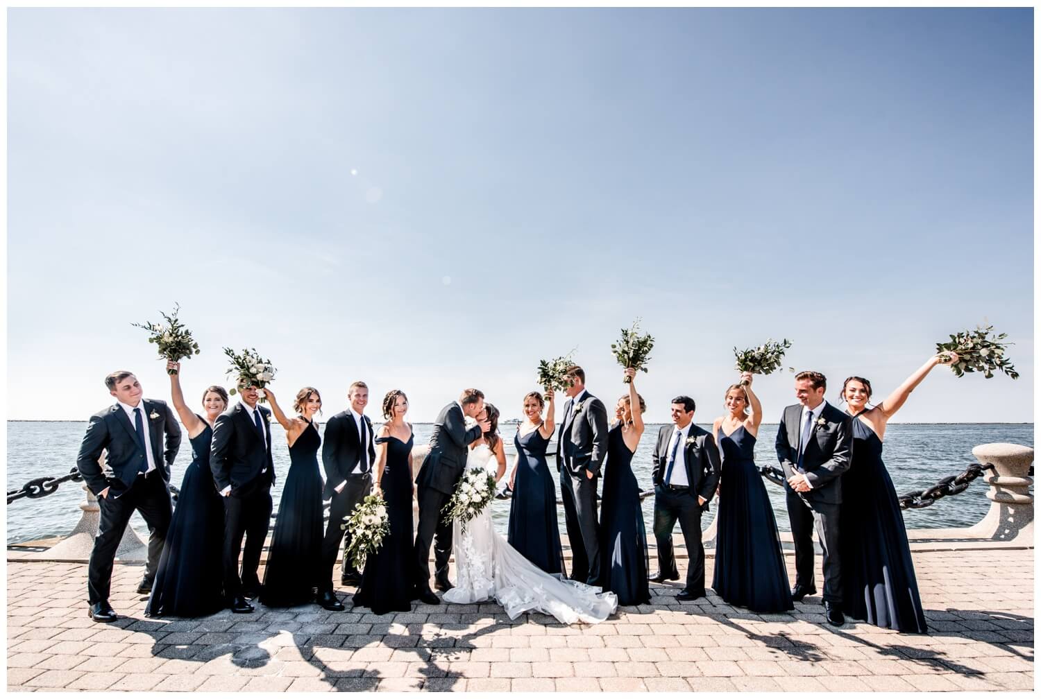 bride and groom with bridal party by lake erie on northeast ohio wedding day in cleveland