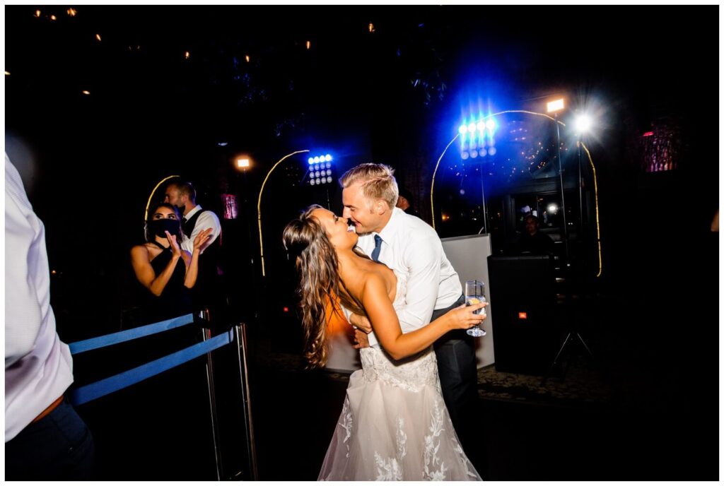 bride and groom dancing and kissing on dance floor at windows on the river wedding reception