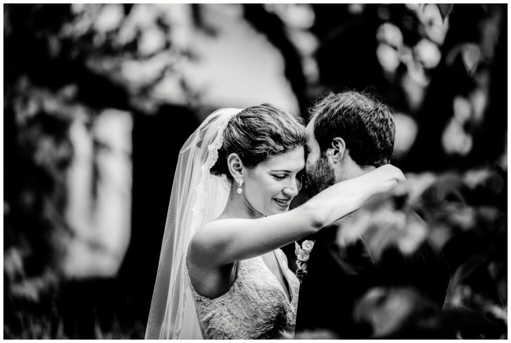 black and white photo of bride and groom hugging outside of walden inn