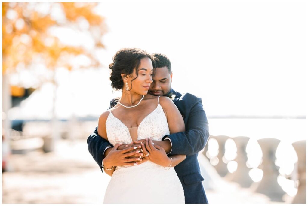 bride and groom cuddled together by lake erie in downtown cleveland