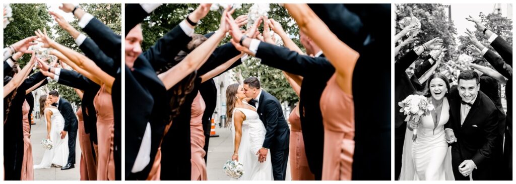 bride and groom kissing while bridal party hold out hands in downtown cleveland on wedding day