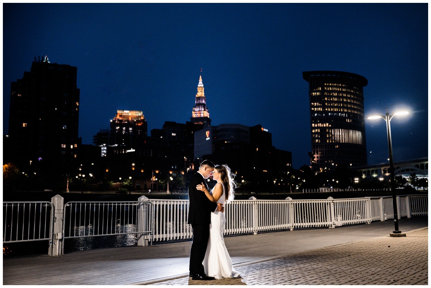 photo of bride and groom in front of cleveland skyline at Windows on the River Wedding at night