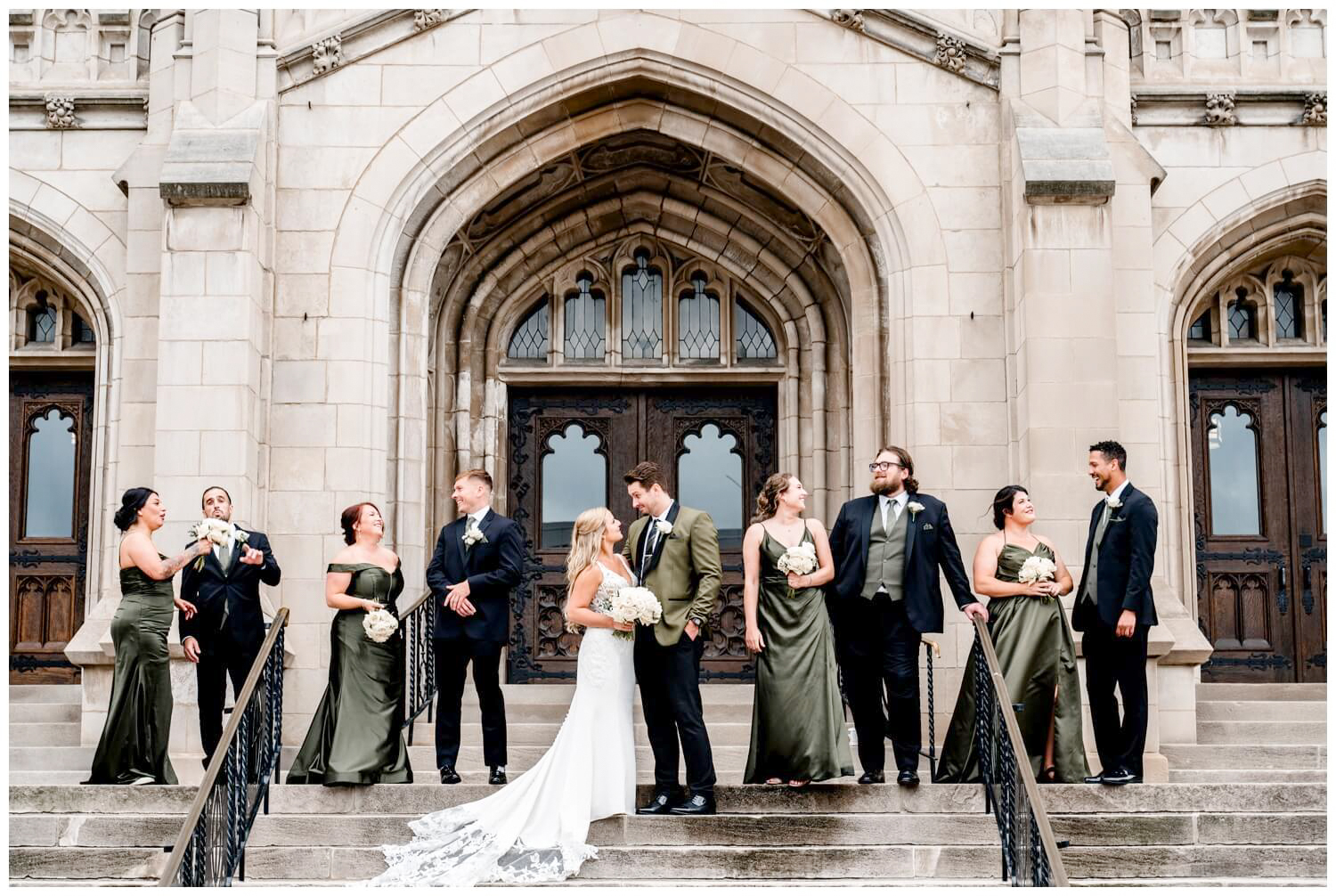 bride and groom posing with bridal party on the steps of the majestic hall in cleveland