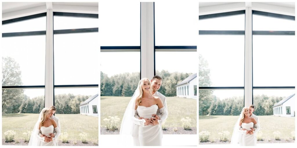 bride and groom hugging and laughing in front of window at the wellspring